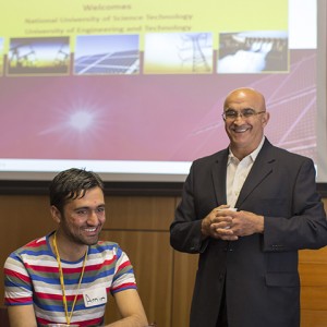 smiling student in striped tee shirt next to smiling man in suit