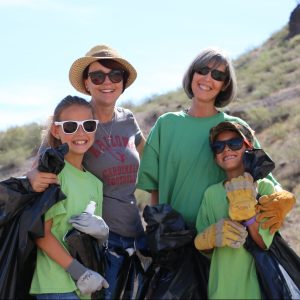 Teachers and students smile while collecting trash at A Mountain