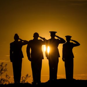 Soldiers saluting at sunset