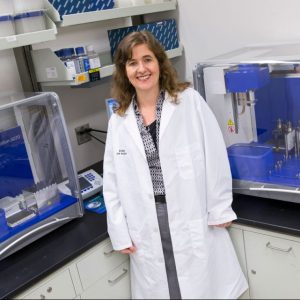 Rosa Krajmalnik-Brown stands in her lab in a white lab coat.